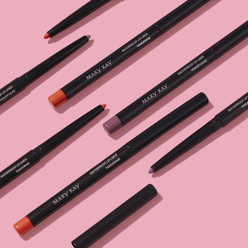 Pattern of special-edition Mary Kay Waterproof Lip Liner pencils in shades Tangerine and Violet Lilac against pink background image number null